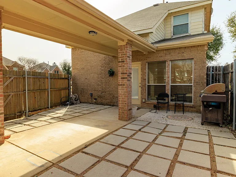Outdoor patio with chairs and grill.