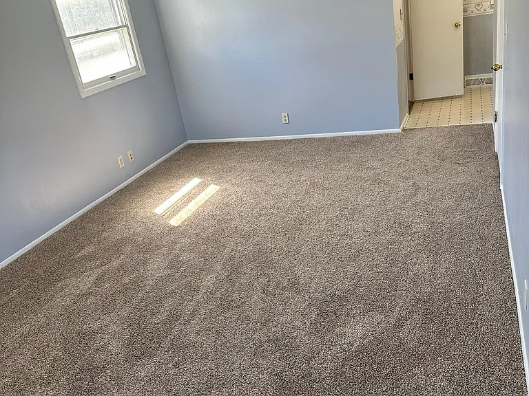 Master bedroom leading to walk in closet and vanity area.