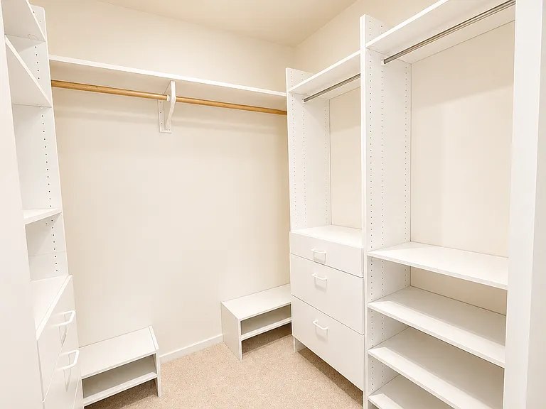 Large closet/ dressing room has useful closet storage system to maximize space.