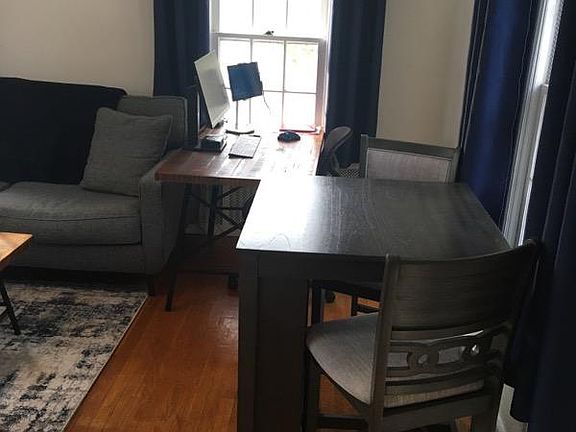 Living room with hardwood floors, unit overlooks a quaint and quiet property