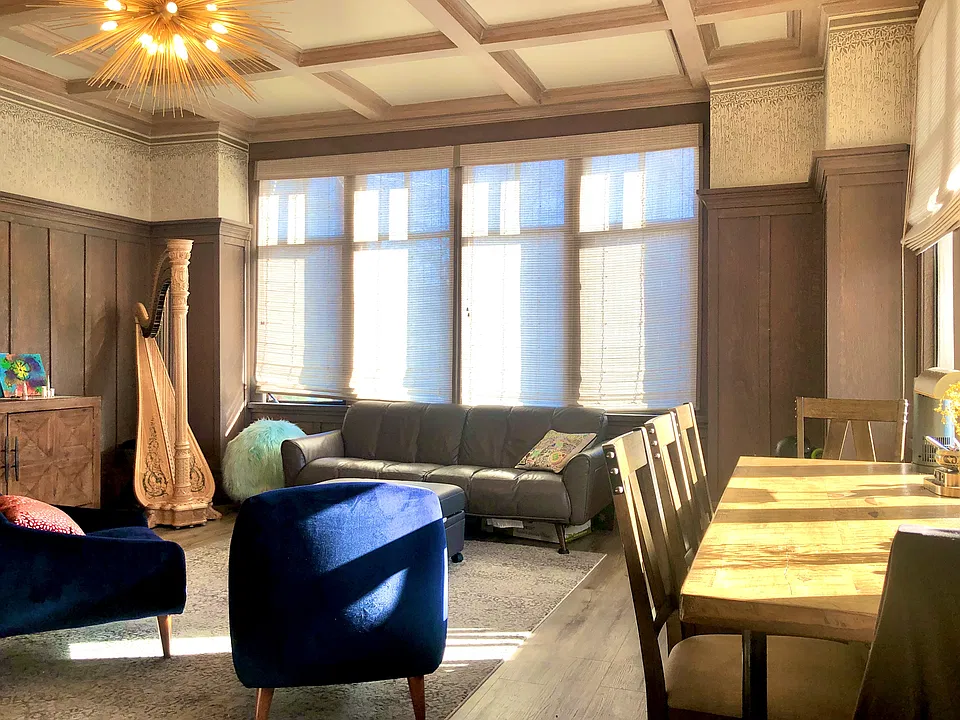Bathed in warm natural sunlight, this inviting living room feels cheerful and uplifting all day long. Light pours in through large west-facing windows and gently filters through shaded southern windows, creating a calm, happy space to gather and study.