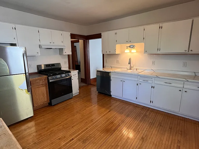Spacious kitchen is off of the dining room. Hardwood floors, lots of cabinets, brand new stainless steel appliances, and enough room for a kitchen table.