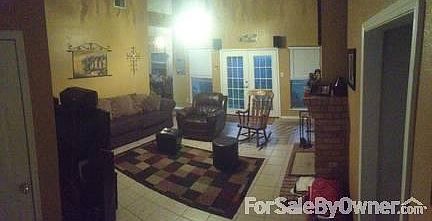 Living Room : Wood burning fire place, tile floors, and vaulted ceilings