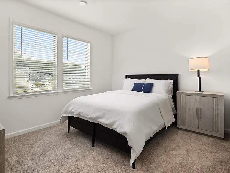 Secondary bedroom with queen size bed and large window letting in a ton of natural light.