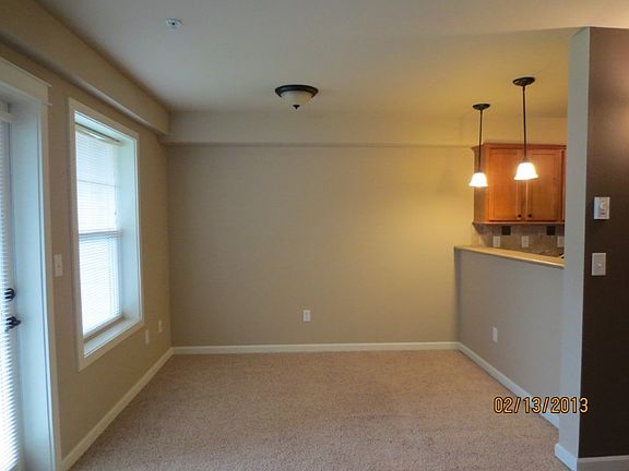 Cozy living area with exit door unto the balcony. Possible eating area for stools by hanging lights.