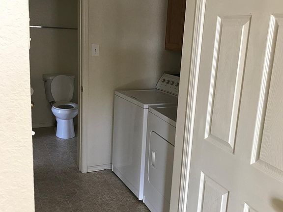 Hallway leading to the restroom has the laundry area