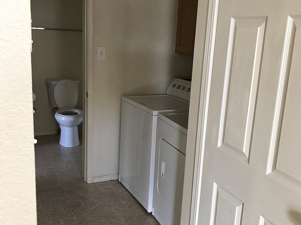 Hallway leading to the restroom has the laundry area