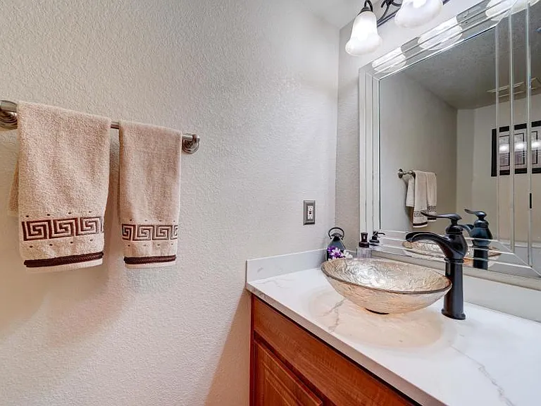 Half bath downstairs with quartz countertop, updated cabinets and vessel sink.