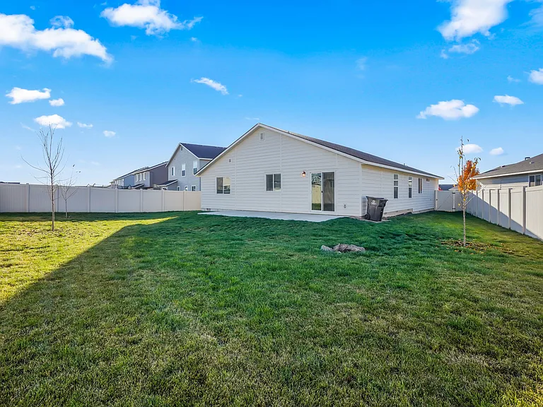 Large fully fenced backyard with trees and sod