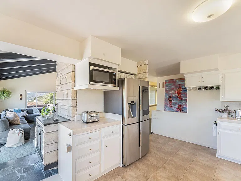 Chef's kitchen with refrigerator and microwave.