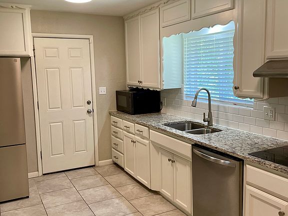 Granite counters, microwave, dishwasher, refrigerator, tile flooring.