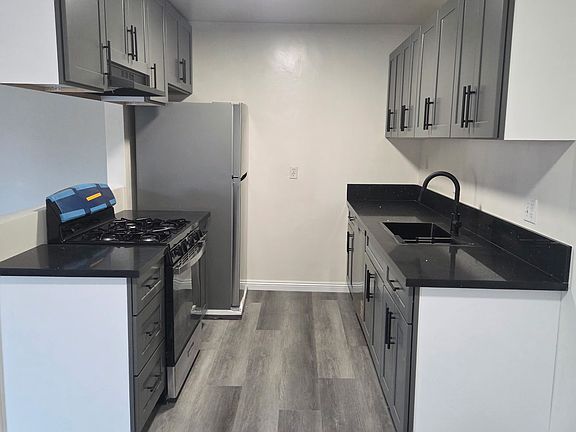 kitchen with new appliances. new stove, fridge, hood, dishwasher and sink.