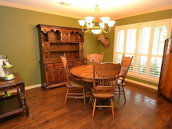 Dining room enhanced by hardwood floors, crown molding, plantation shutters and access to the kitchen.