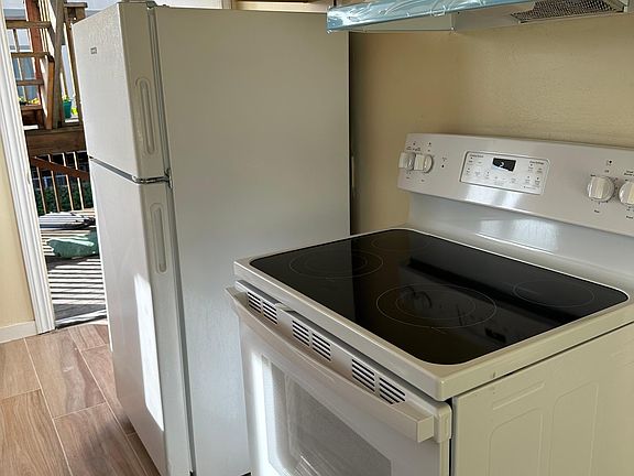 Kitchen with new range/oven. Door to back deck and yard. New floors and paint.