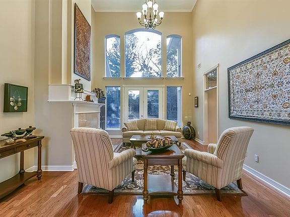 The Great Room boasts a wall of windows with panoramic views of the resort style backyard and grand fireplace.