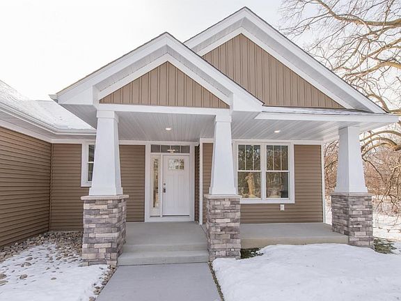Welcome guests on the porch. Step through the custom front door with transom window and sidelight!