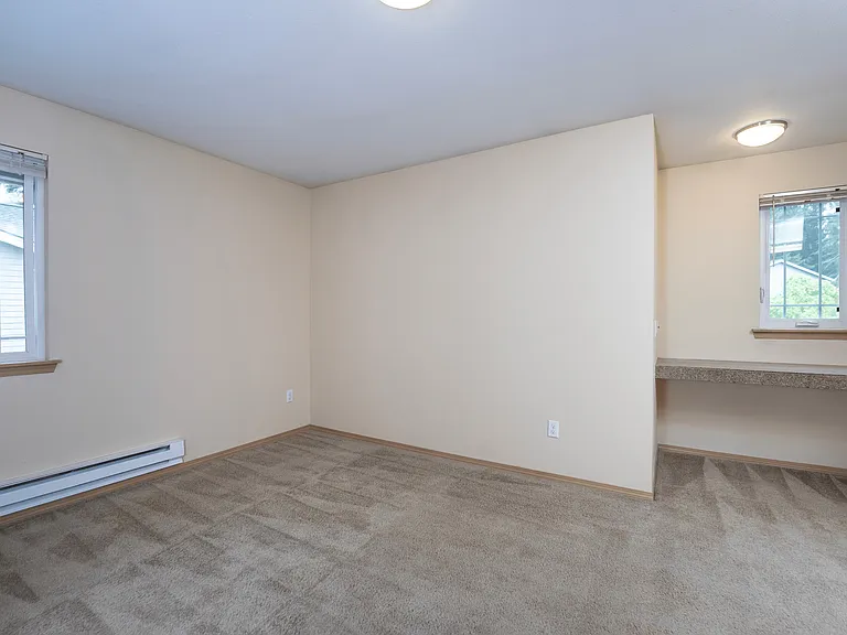 Bright and spacious! _ This inviting bedroom features multiple windows for plenty of natural light, cozy carpet flooring, and a built-in desk_perfect for work or study. Bright and spacious! _ This inviting bedroom features multiple windows for plenty of n