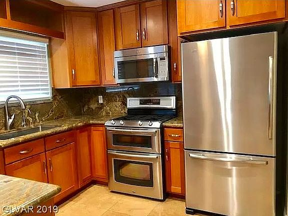 Kitchen with cherry wood cabinets, stainless steel appliances and granite countertops