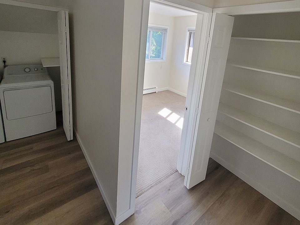 hall view looking into bedroom, showing linen closet and laundry room