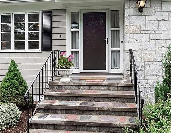 Beautiful front entrance with stone walkway and front steps in excellent condition with wrought iron railing.