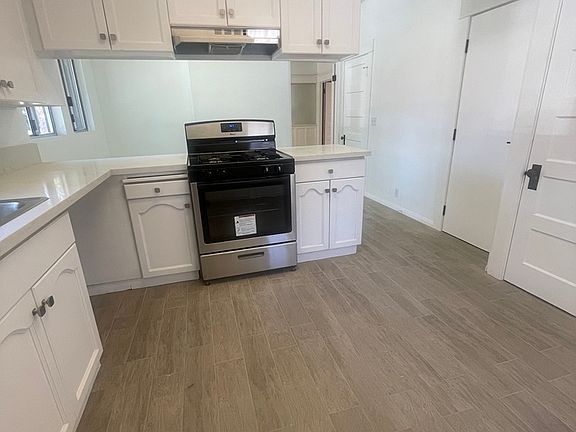 Large, updated kitchen with new quartz countertops, stove/oven and new tile floor with the appearance of wood.