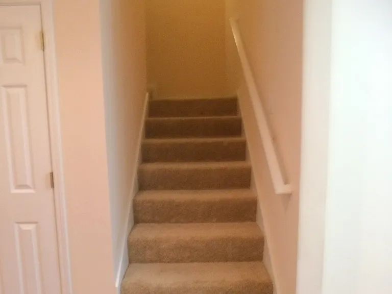 Stairway to two bedrooms and a bathroom upstairs.
