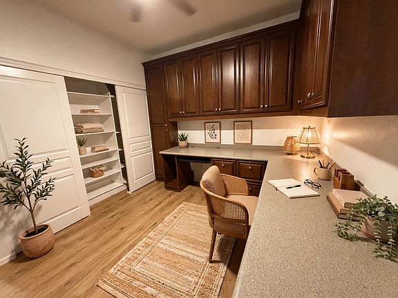 Private downstairs office with custom built-in cabinetry, a wraparound workspace.