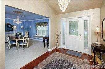 Formal foyer with beautiful wood floors leads to large formal di