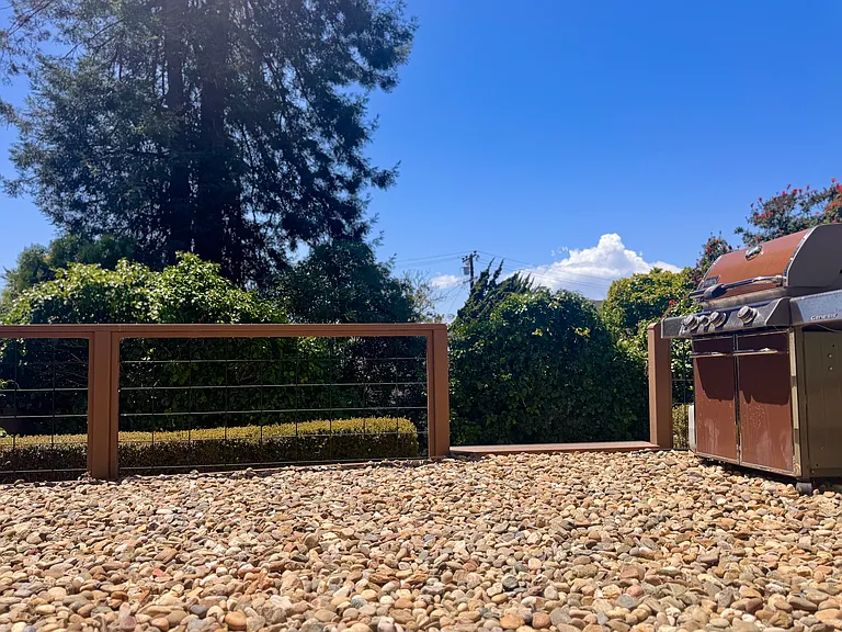 The second level offers an outdoor entertaining space with bay views and a Weber propane grill.