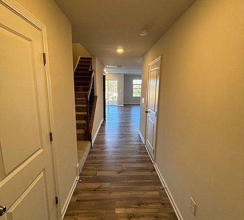 From front entry, powder room on left, garage door on right, pantry understairs, stairway to upstairs bedrooms and laundry room. Open living, dining, and kitchen at back of house with private rear entrance patio.