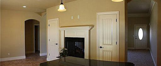 Kitchen and dining room area looking into living room and spare bedroom/laundry/bath hall.