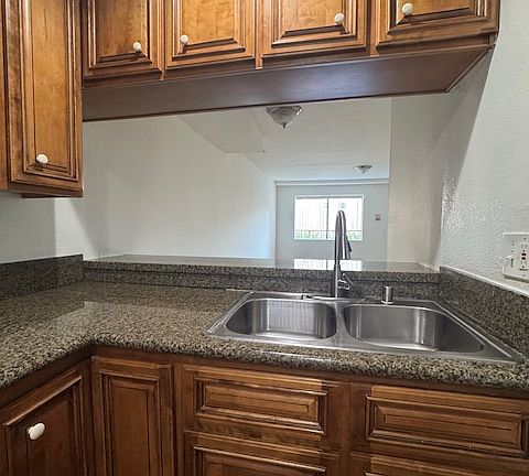 Stainless sink and breakfast bar behind