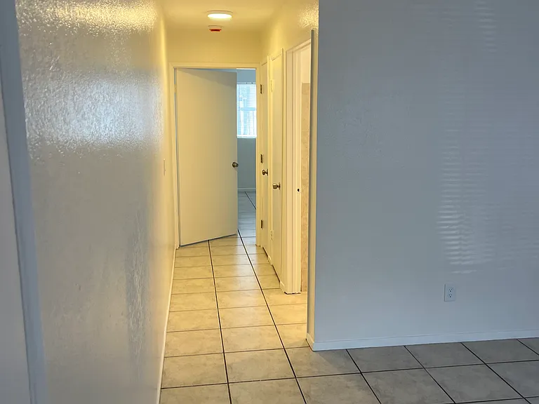 Looking down hallway from living room, towards bedroom.