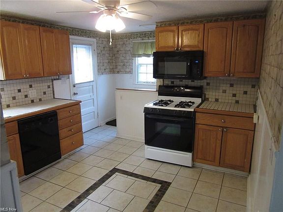 Eat-in kitchen with plenty of cabinet space and overlooks the back yard. Kitchen includes a refrigerator, gas stove, dishwasher and microwave. Kitchen provides entrance to lower level and backyard