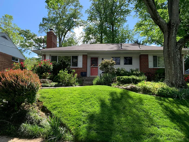 Beautifully landscaped front lawn with paved walkway and steps