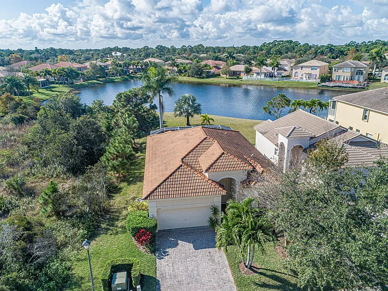 Front view of the house, 2 car garage, natural preserve on one side of the house, lake behind of the house.
