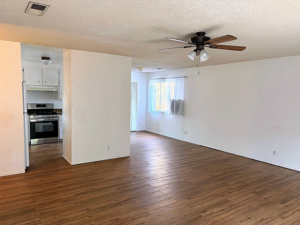 Spacious living room and open dining room connected to kitchen.