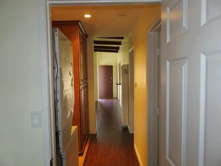 View is looking from back bedroom to hallway and front door.