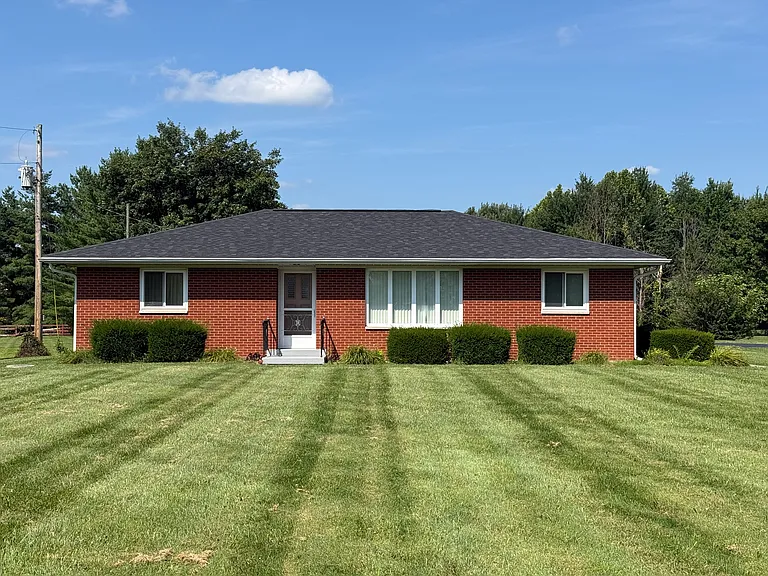Brick ranch house with large front yard. Back wooded lot.