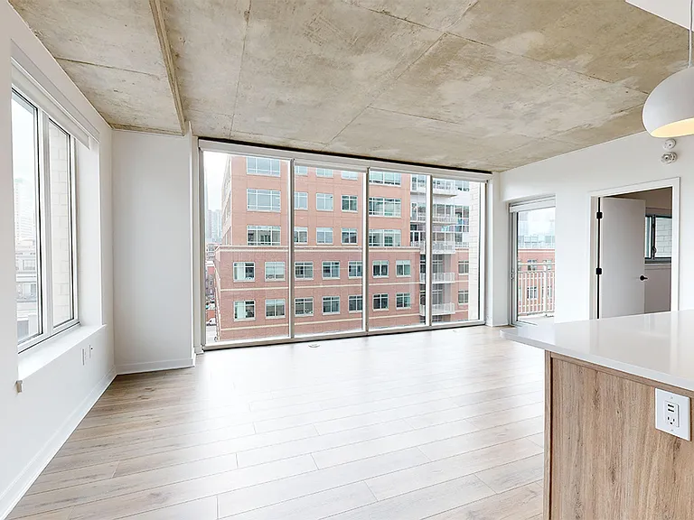 Apartment dining and living room with wood-style flooring.