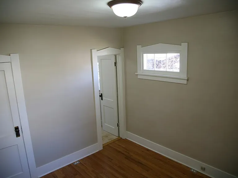 The front bedroom with the closet door on the left, and the bathroom door on the right.