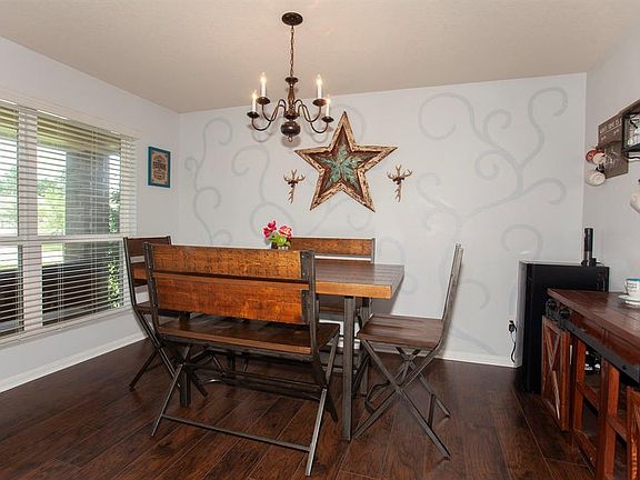 Warm wood laminate floors, custom paint, a stylish chandelier and natural light come together in your chic dining room...