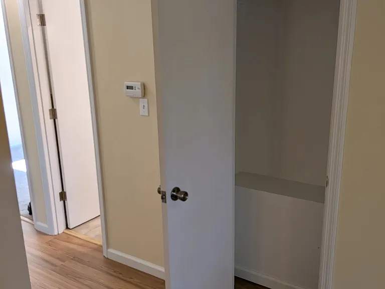 Coat closet in living room, hallway, and door to bathroom.