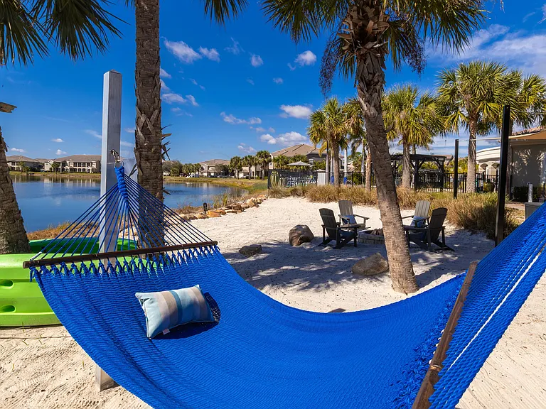 Enjoy ultimate relaxation with a shaded hammock, palm trees, and stunning lakeside scenery.