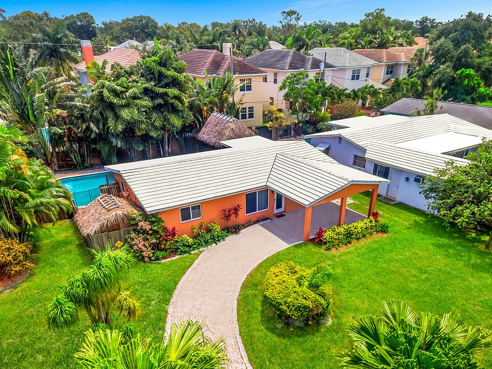 Welcome to Fort Lauderdale! This 3BR home features a lushly landscaped pool area with tiki hut and outdoor dining area.