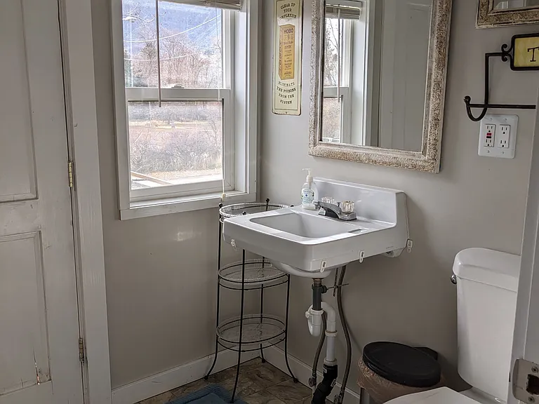 Upstairs 1/2 bathroom. Includes hanging storage and balcony entrance.