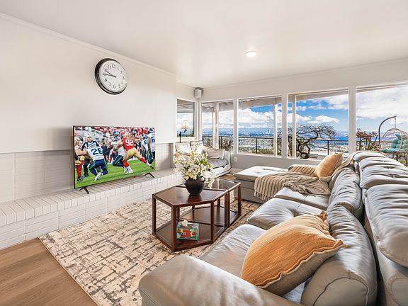 This spacious open-concept living area features a cozy leather sectional sofa, a stylish coffee table,a 65-inches Smart TV and large windows showcasing stunning views. Perfect for relaxing or gathering with loved ones!