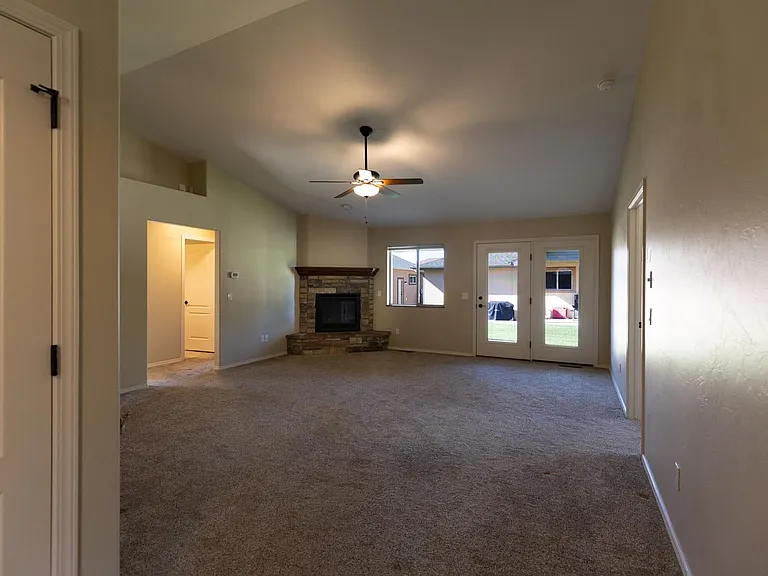 View from entry into living room with corner gas fireplace