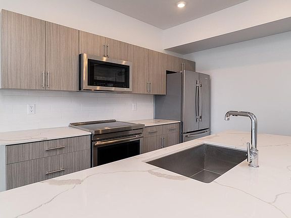 Clean White Tile Backsplash with Chrome Hardware.