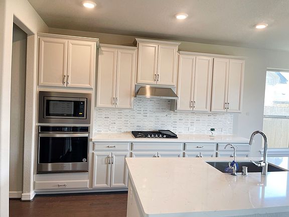 Kitchen with white cabinets, modern tile backsplash and open to butlers pantry